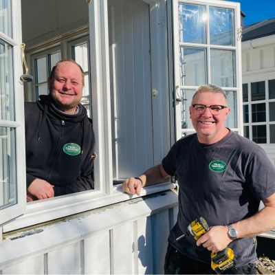 two men standing in a window
